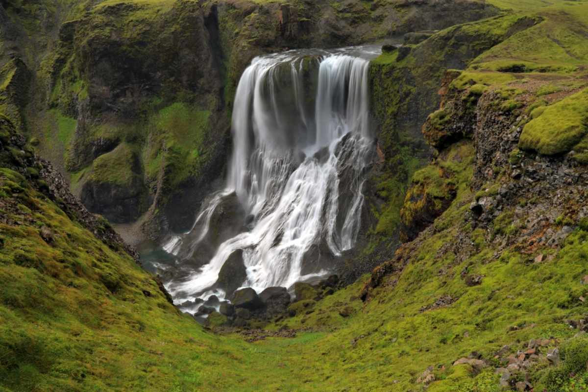 Fagrifoss waterfall cascading into a mossy canyon along F206.