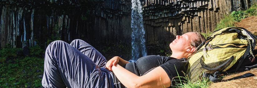 Sunrise over Icelandic mountains with a white campervan on a quiet road, illustrating savings and wider availability when you book early.