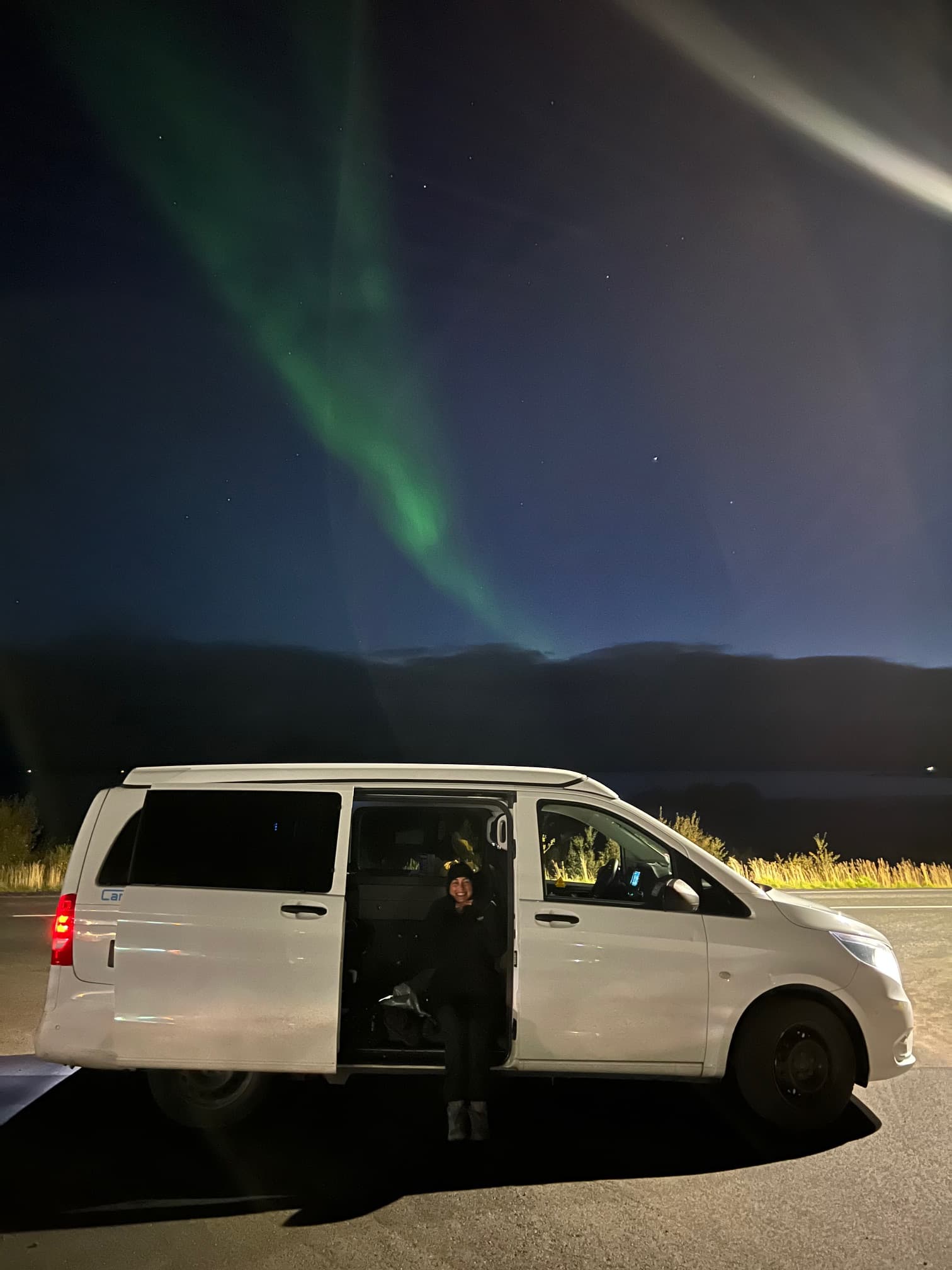 Campervan parked under the aurora borealis