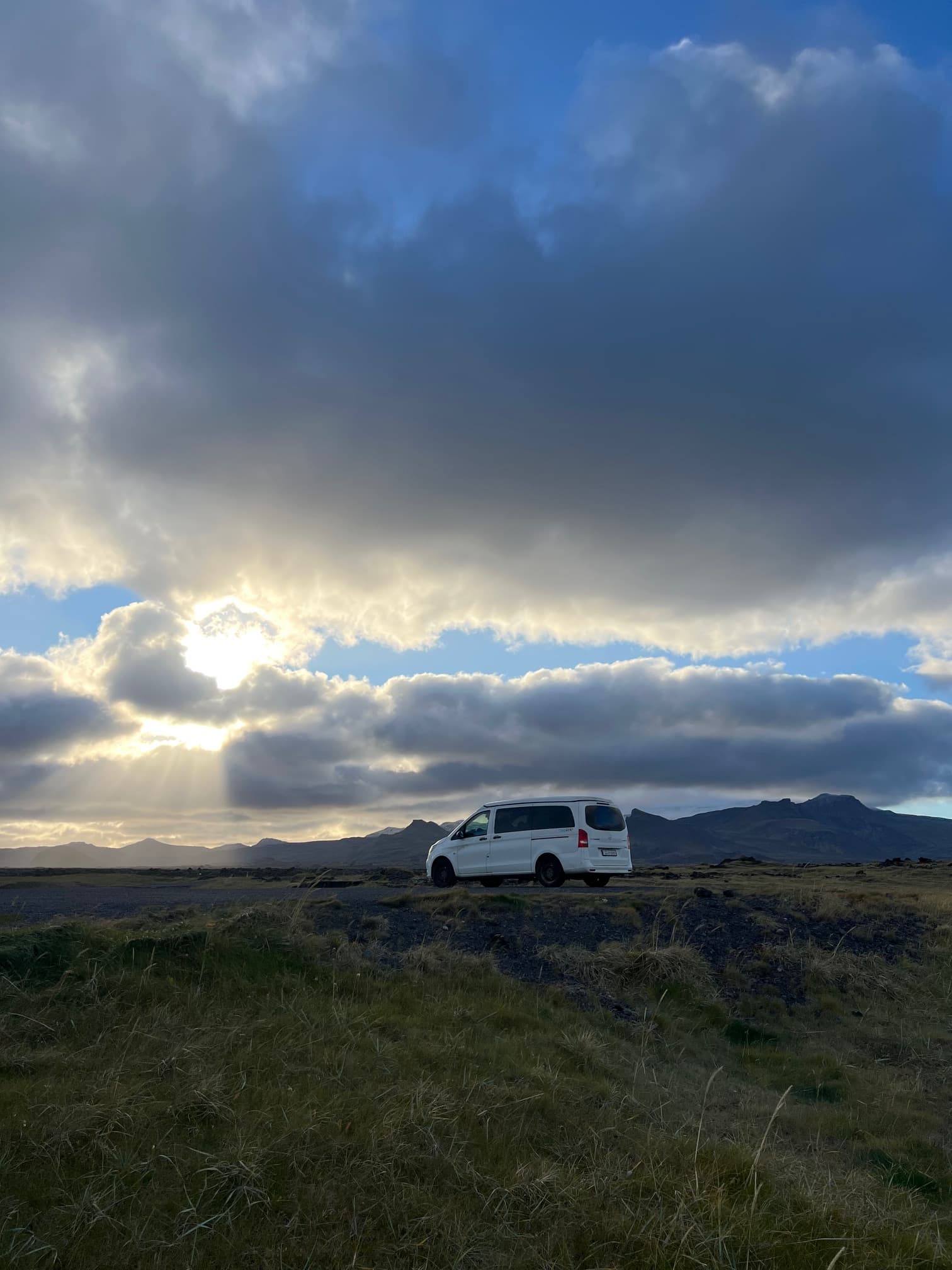 Campervan on Icelandic road with dramatic sky