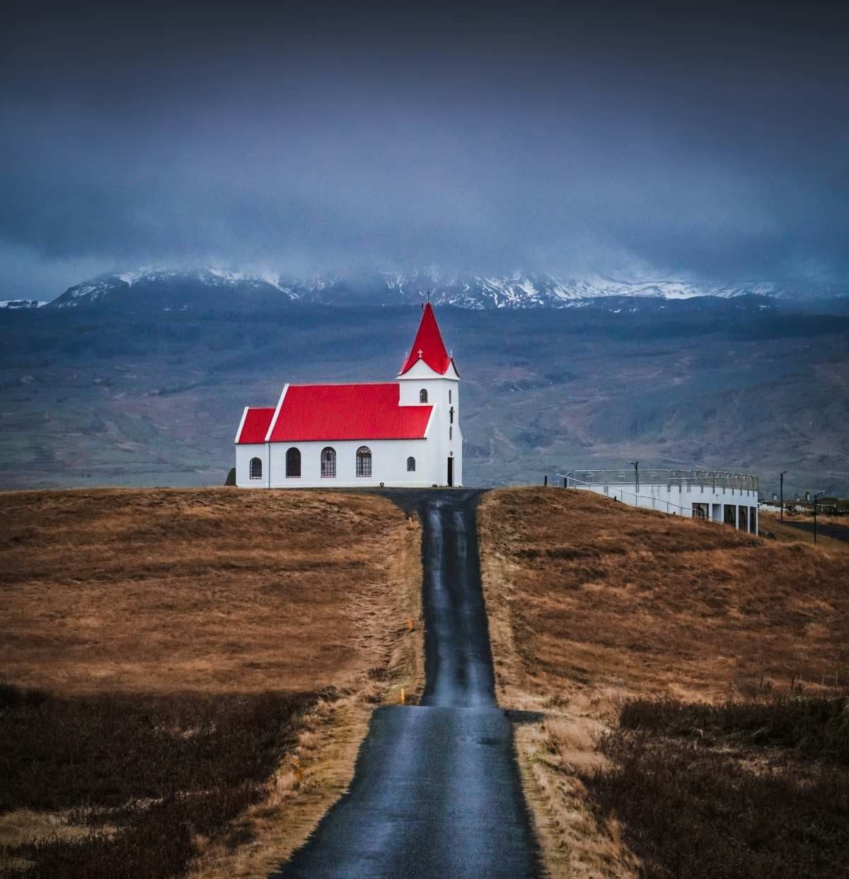 Road leading to a red roof church in Southern Iceland