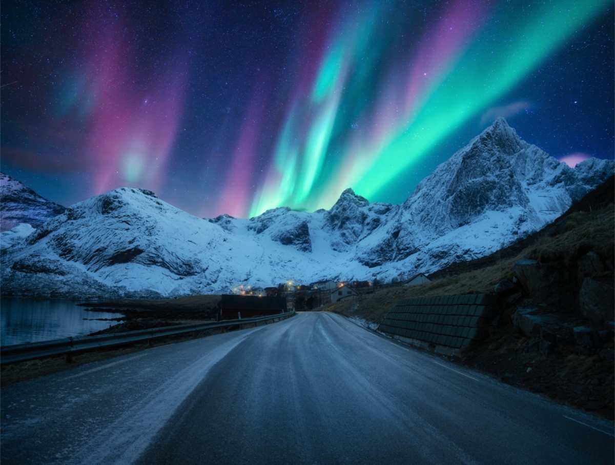 The ring road of Iceland with impressive mountains and the northern lights shining 