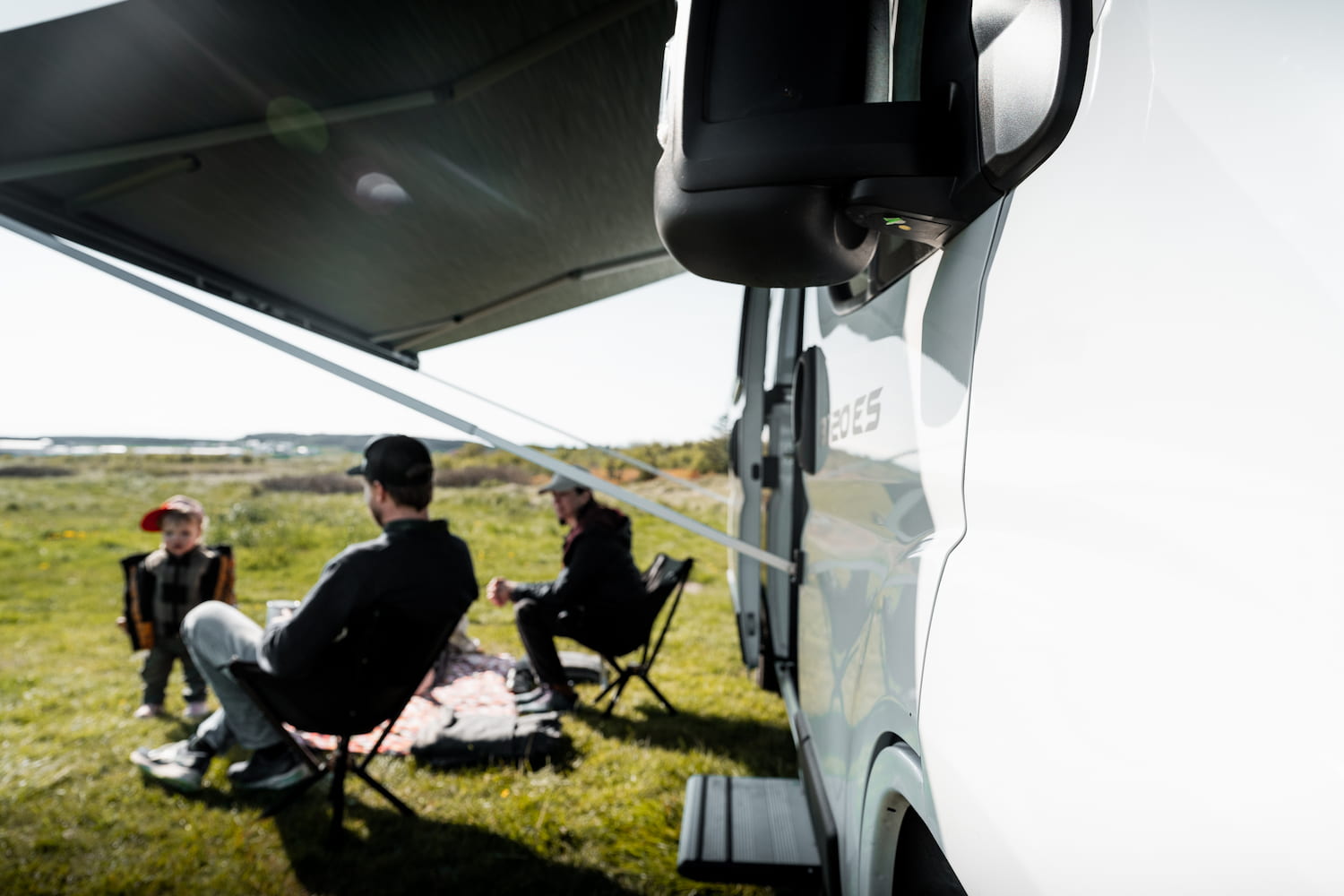 Meet the friendly team behind your Iceland campervan adventure Smiling campervan rental staff welcoming traveller beside white shuttle bus, representing our friendly Iceland airport transfer and customer service.